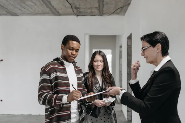 A diverse couple signing documents with a realtor in a new home setting. Where SBA 504 and 7(a) borrower equity really comes from
